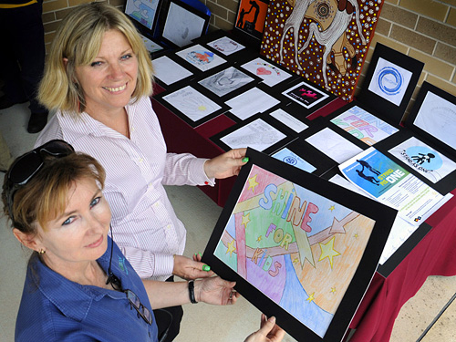 SHINE CEO Gloria Larman and teacher Helene Culleton with the competition entries